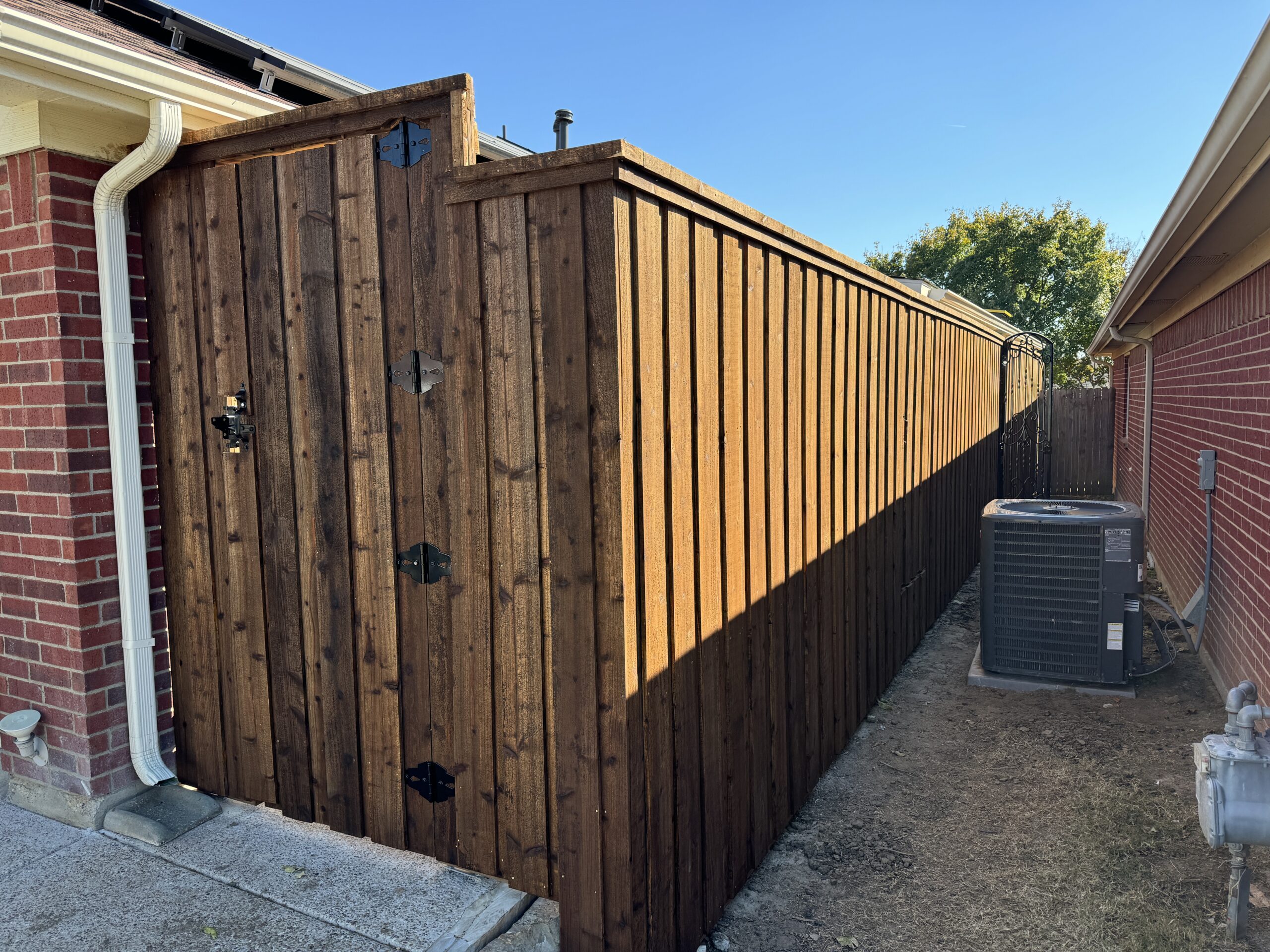8ft board on board stained cedar privacy fence with cap and trim and a manual gate in Arlington, TX by M&C Fence DFW